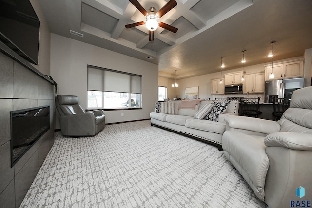 carpeted living room with coffered ceiling, beam ceiling, a fireplace, and ceiling fan