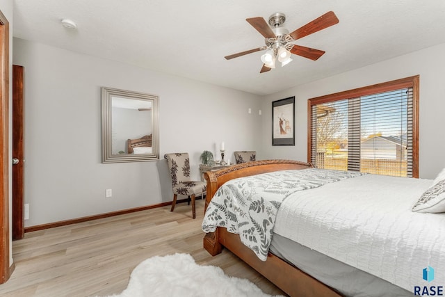 bedroom with ceiling fan, a textured ceiling, and light hardwood / wood-style floors