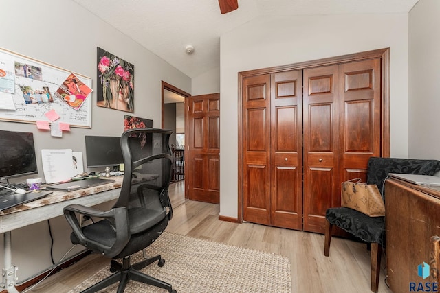 office space featuring ceiling fan, lofted ceiling, and light wood-type flooring