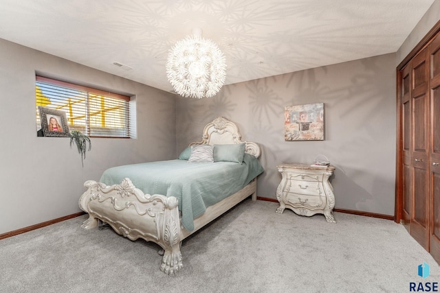 bedroom with light colored carpet, a notable chandelier, and a closet