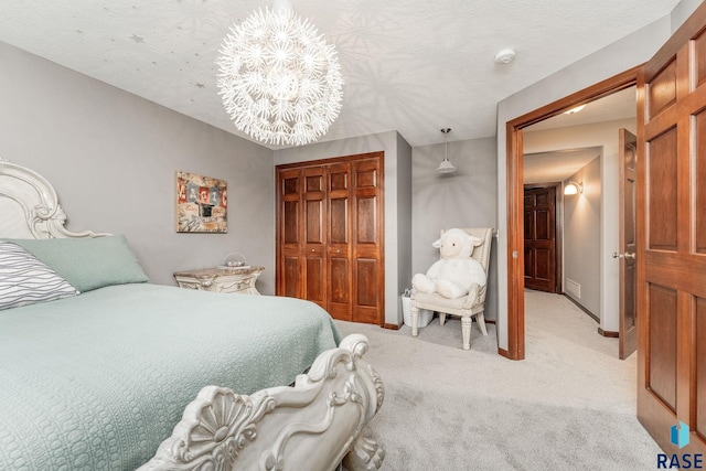 bedroom featuring light colored carpet, a textured ceiling, and a closet