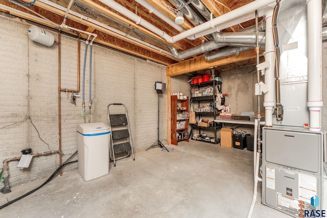 basement featuring heating unit and brick wall