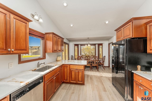 kitchen featuring pendant lighting, sink, black fridge with ice dispenser, stainless steel dishwasher, and kitchen peninsula