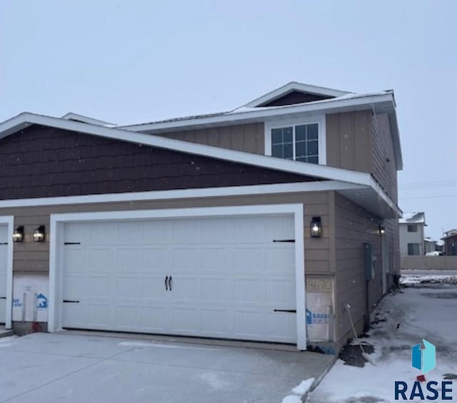 view of snow covered exterior featuring a garage