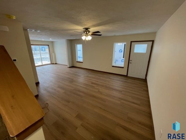 foyer entrance featuring ceiling fan, hardwood / wood-style flooring, and a textured ceiling