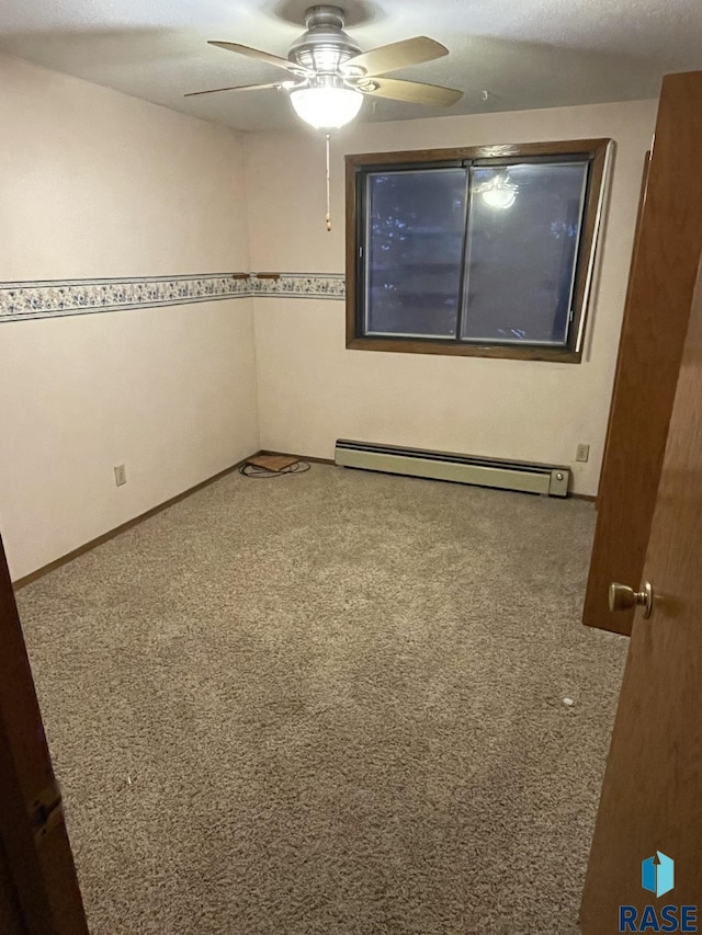 carpeted empty room with baseboard heating and ceiling fan