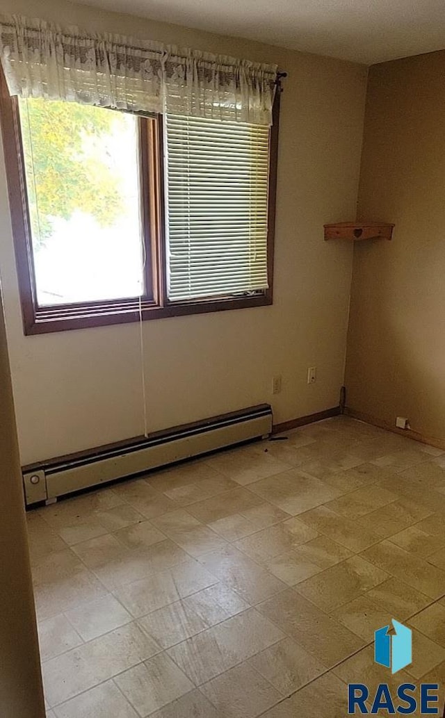 unfurnished room featuring baseboard heating