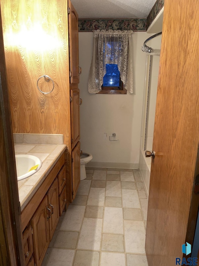 full bathroom with toilet, vanity, shower / bath combination with glass door, and a textured ceiling