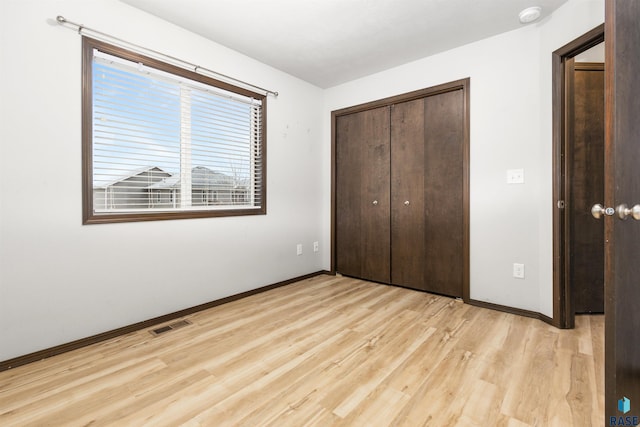 unfurnished bedroom with light hardwood / wood-style flooring and a closet