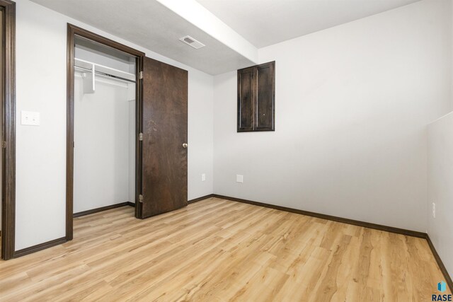 unfurnished bedroom featuring light wood-type flooring and a closet