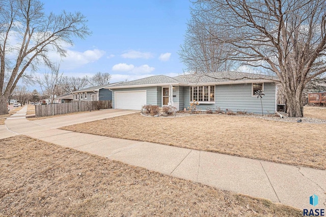 ranch-style home featuring a garage and a front lawn