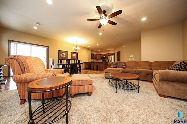 living room with ceiling fan with notable chandelier