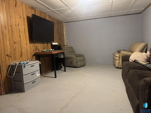 living room featuring wood walls and concrete floors