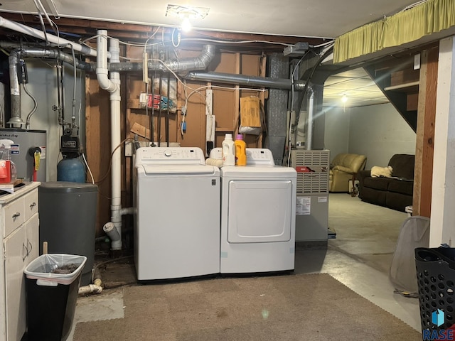 laundry room with water heater and separate washer and dryer