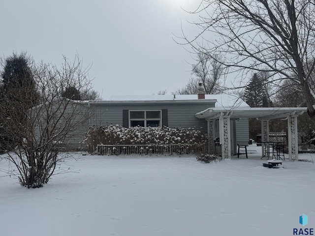 snow covered property featuring a chimney