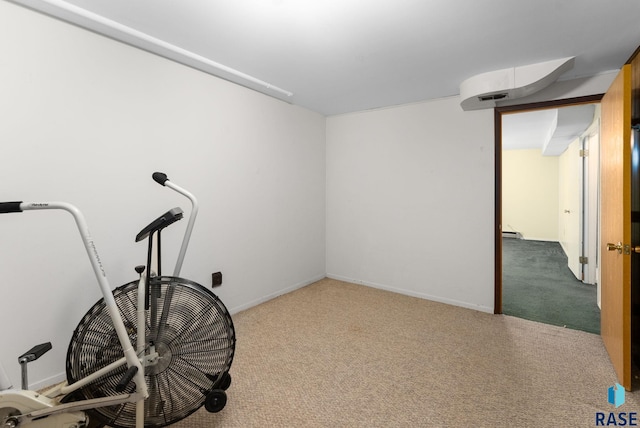 workout area featuring a baseboard heating unit and carpet flooring