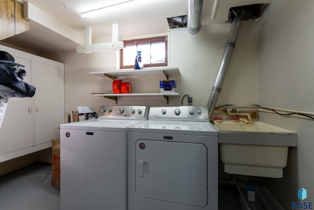 clothes washing area with separate washer and dryer and sink