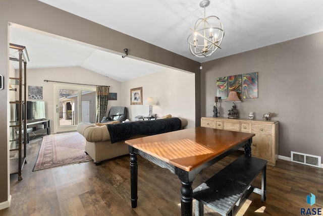 dining area with vaulted ceiling, dark wood-type flooring, and a chandelier