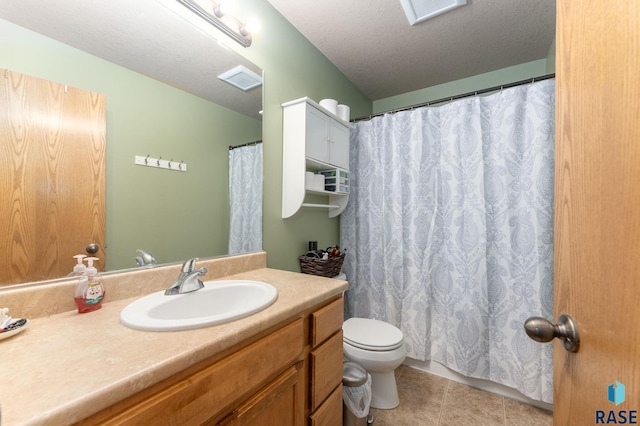 bathroom with tile patterned flooring, vanity, a textured ceiling, and toilet