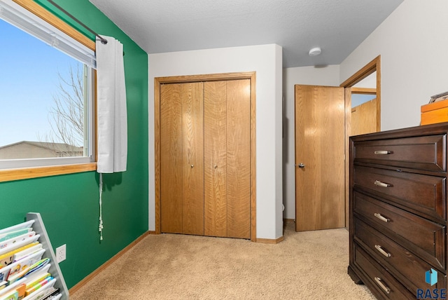 unfurnished bedroom with light colored carpet and a closet