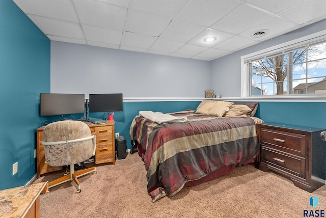 carpeted bedroom with a drop ceiling