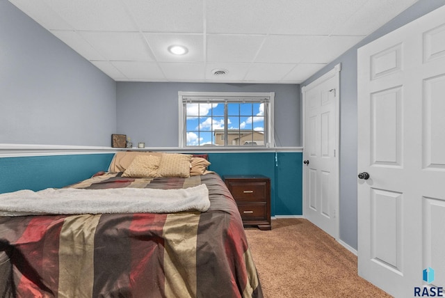 bedroom with carpet floors and a drop ceiling