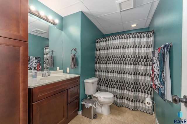 bathroom with vanity, a drop ceiling, and toilet