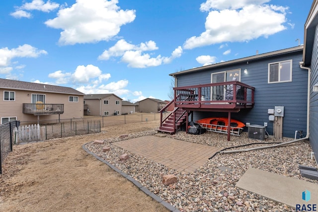 back of property with central AC unit, a deck, and a patio