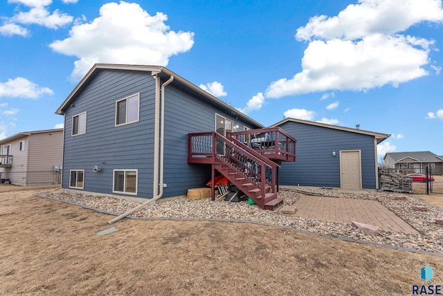 back of property with a wooden deck and a lawn