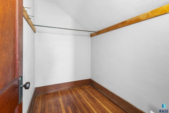 walk in closet featuring wood-type flooring and vaulted ceiling