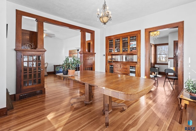 dining space with wood-type flooring and a chandelier