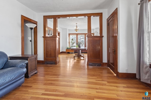 interior space featuring an inviting chandelier and light hardwood / wood-style flooring