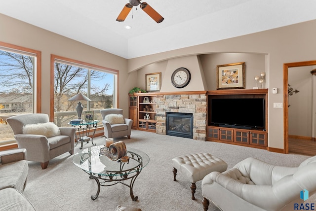 carpeted living room with a fireplace and ceiling fan