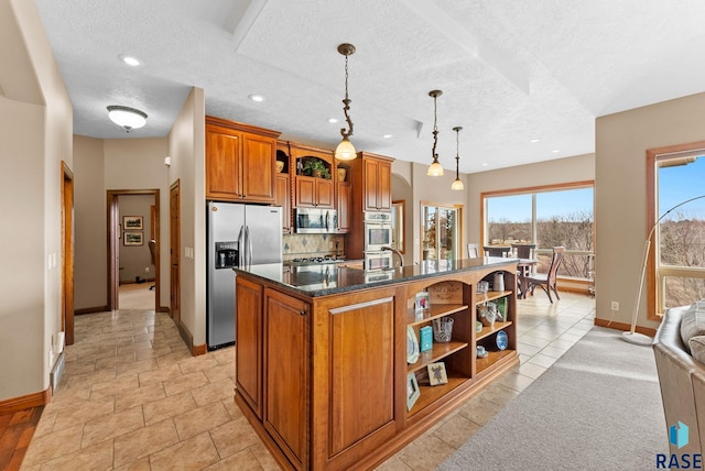 kitchen with a center island with sink, appliances with stainless steel finishes, pendant lighting, dark stone counters, and backsplash