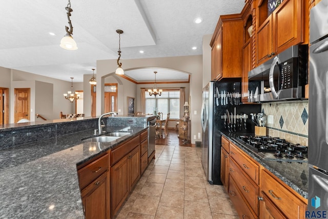 kitchen with hanging light fixtures, dark stone counters, and a chandelier