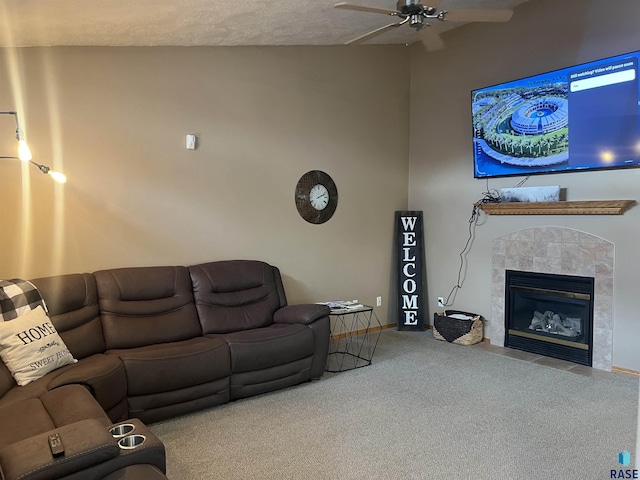 carpeted living room featuring ceiling fan, a fireplace, and a textured ceiling