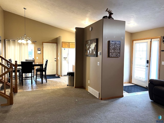 interior space with vaulted ceiling, light carpet, a textured ceiling, and a chandelier