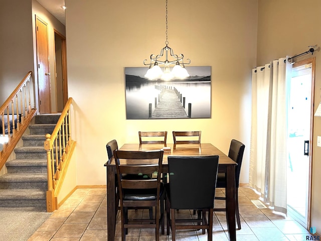 tiled dining room with a healthy amount of sunlight and a chandelier