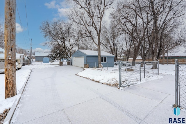 yard layered in snow with a garage and an outdoor structure