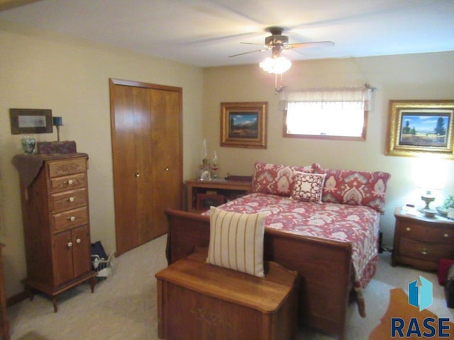 bedroom featuring light colored carpet, a closet, and ceiling fan