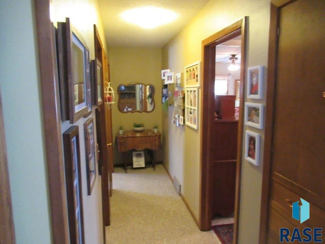 hall featuring light colored carpet