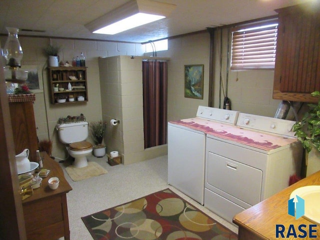 laundry room featuring tile walls and washing machine and clothes dryer