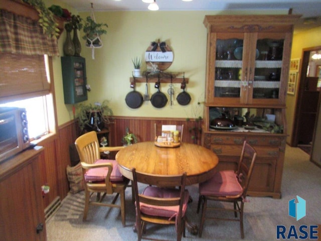 dining room with wooden walls and carpet