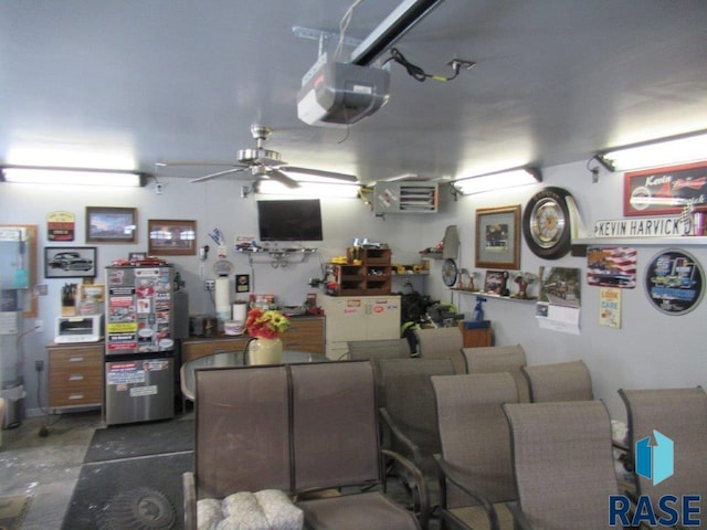 garage featuring a garage door opener, ceiling fan, and white refrigerator