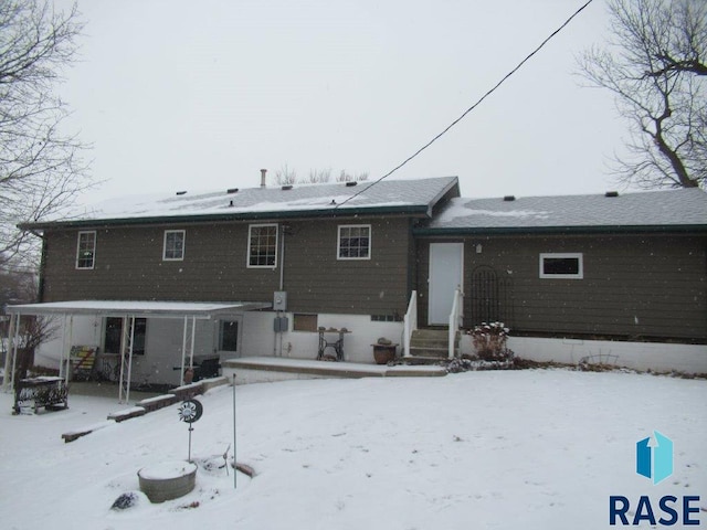 view of snow covered rear of property