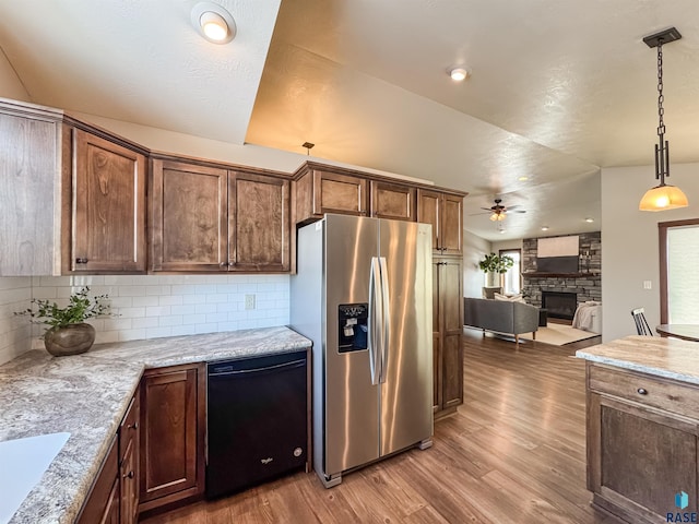 kitchen featuring stainless steel refrigerator with ice dispenser, decorative light fixtures, dishwasher, and light stone counters