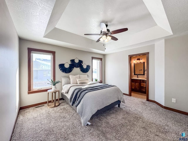 bedroom featuring ceiling fan, a tray ceiling, carpet floors, and a textured ceiling