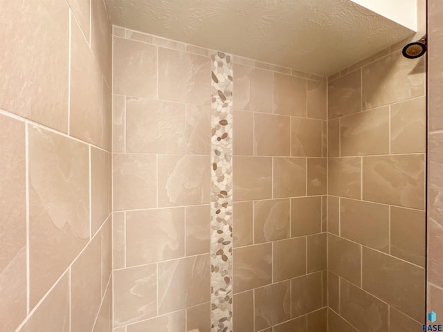 room details with a tile shower and a textured ceiling