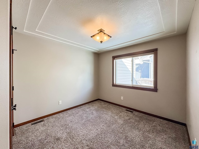 carpeted empty room featuring a textured ceiling