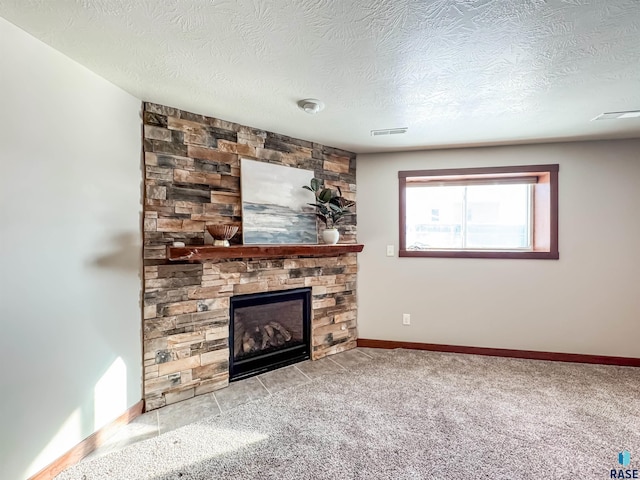 unfurnished living room featuring light carpet, a stone fireplace, and a textured ceiling